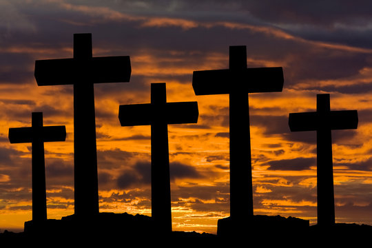 crosses silhouette against the sky at sunset