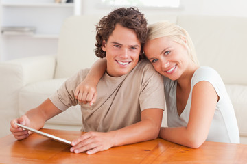 Hugging cute couple with a tablet