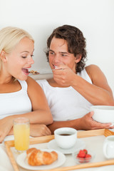 Obraz na płótnie Canvas Portrait of a smiling couple eating breakfast