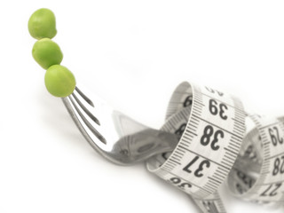 diet, fork with measuring tape and peas