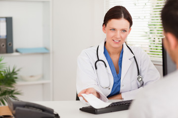 Female doctor giving patient prescription