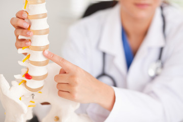 Doctor pointing at bone in spine