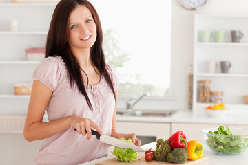 Obraz na płótnie Canvas Cute woman cutting vegetables