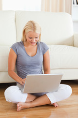 Woman using a laptop while sitting on the floor