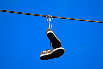 tennis shoes hanging from a power line