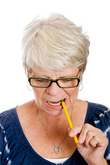 Elderly woman biting a pencil while thinking