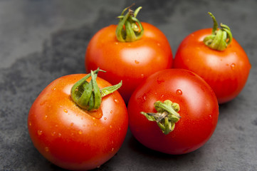 4 reife Tomaten auf Schieferplatte