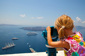 Fototapeta na wymiar Dziewczyna patrząc przez lornetkę w Thira, Santorini, Grecja