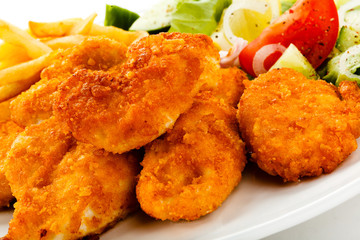 Fried chicken nuggets, French fries and vegetables