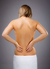 Naklejka premium Woman massaging pain back isolated on white