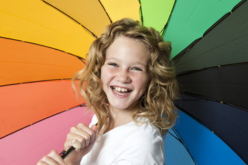 Happy smile from a girl with Rainbow umbrella.