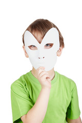 Little boy in green t-shirt hides his face behind mask