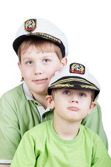 Two boys in green T-shirts and white sea peak-caps