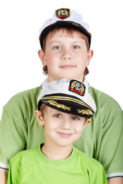two boys in green T-shirts and white sea peak-cap