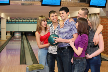 Fellow holds ball for bowling and friends stand alongside