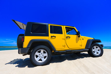 Fototapeta na wymiar ¯ółty Jeep On The Beach