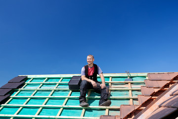 dachdecker sitzt auf dem dach