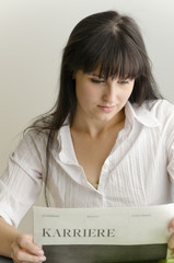 Junge Frau liest Karrierezeitung