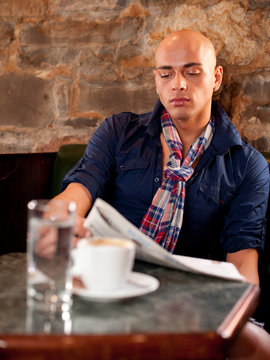 Morning coffee and news - Handsome young man reading newspaper i