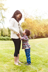 Pregnant Asian mother and her son