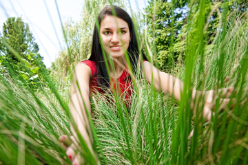 Fototapeta premium Woman Peering Through Grass