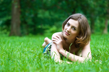 beautiful woman is lying on the grass