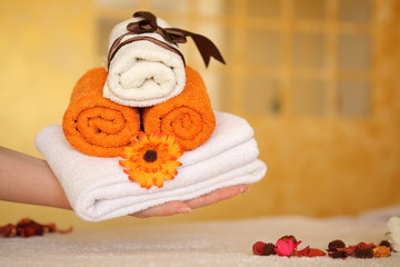 Fototapeta na wymiar beautiful spa scene with towels, flower, hand holds towels