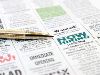 Pen on the newspaper career opportunity ad.