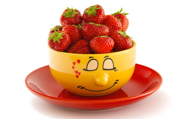 Yellow bowl on a red saucer with strawberries, isolated on white