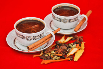 Black coffee and spices isolated on red