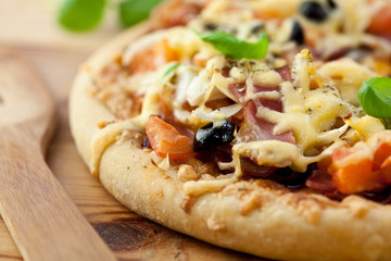 Rustic pizza on wooden background