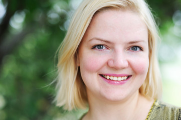 Fototapeta premium portrait of beautiful happy blond woman in the park