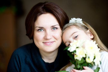 Beautiful mother and daughter with white flowers