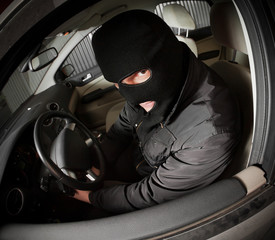 robber and the thief in a mask hijacks the car
