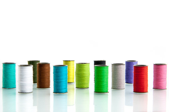 Pile of coloured bobbins of lurex thread