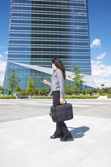 businesswoman with smartphone and briefcase