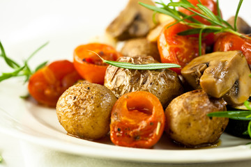 Baked potatoes and tomatoes with mushrooms