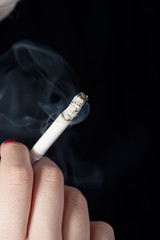 Girl holding cigarette - low key lighting for effect