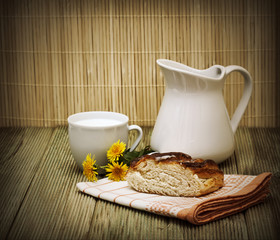 pitcher of milk and a piece of cake on a wooden table
