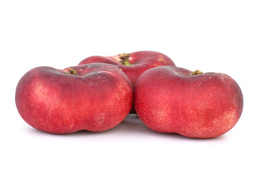 Three red flat peaches