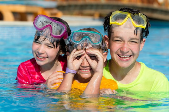 Three Smiling Children in Pool