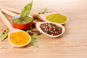 spices in the spoons on wooden background