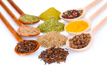 spices in the spoons isolated on white