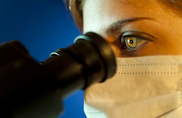 scientific looking in microscope