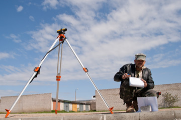 Theodolite on a tripod with construction worker