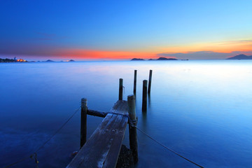 Sunset at dusk along a wooden pier, high saturation image.