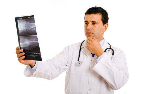 Young Doctor looking at an x-ray, isolated on white