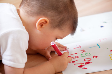 Little boy writing his first letters