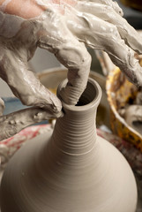 hands of a potter, creating an earthen jar on the circle