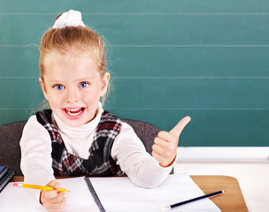 Schoolchild in classroom near blackboard.